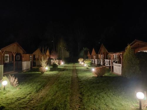 a yard with a row of houses at night at Domki Słoneczny Brzeg in Dąbki