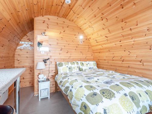 a bedroom with a bed in a wooden cabin at Ewe Two in Flint