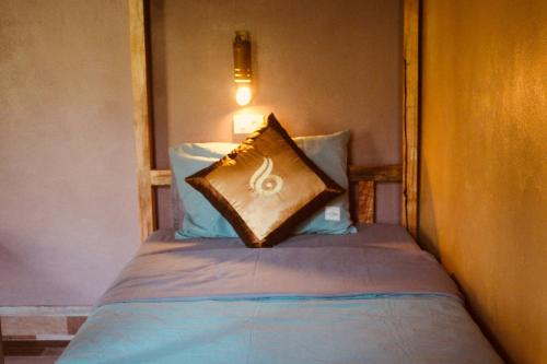 a bed with a pillow sitting on top of it at Ba Be Hostel in Bak Kan