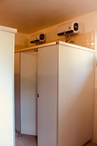 a white cabinet with two monitors on top of it at Ba Be Hostel in Bak Kan