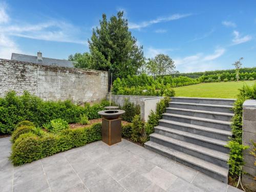 a garden with stairs and a stone wall at Spacious Family Holiday Home in Mont-de-l'Enclus