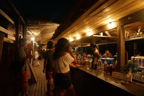 a group of people standing at a bar at night at The Bath & Bed Hayama in Hayama
