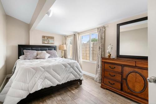 a bedroom with a bed and a television on a dresser at Oceanside Rocks Family Vacation Home in Oceanside