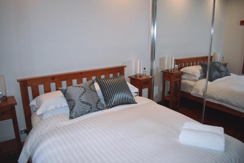 - une chambre avec 2 lits et un miroir dans l'établissement River Vibes Devonport, à Devonport