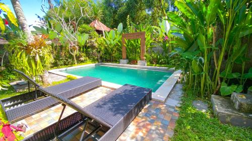 - une petite piscine avec un banc et une table dans l'établissement Ubud River Campuhan Villa, à Ubud