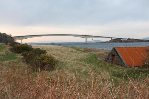 a bridge over a body of water with a building at Misty Isle Apartments Ltd - Maol View in Kyleakin