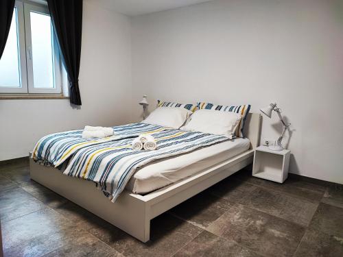a bedroom with a bed with a striped comforter at Bellavista Resort in Koper
