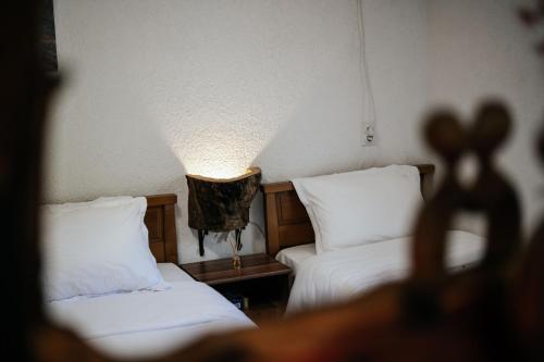 a room with two beds and a lamp on the wall at Markovic Village Apartments in Ulcinj