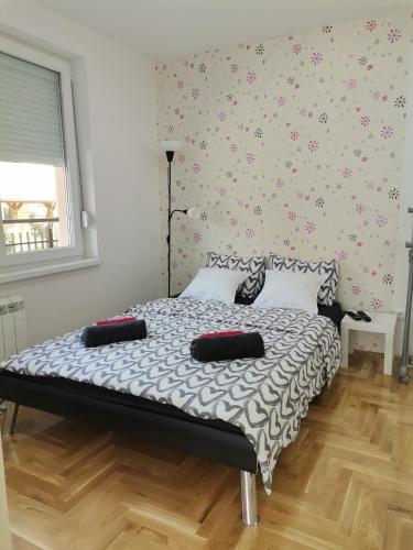 a bedroom with a bed with a black and white comforter at JOKER Apartman in Požarevac