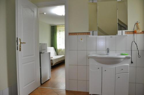 a white bathroom with a sink and a living room at Vila Krantas in Palanga