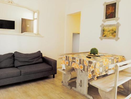 een woonkamer met een tafel en een bank bij Le Case Del Grillo in Trapani