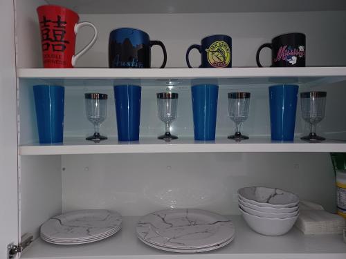 a shelf with blue cups and plates and glasses at Hacienda Gallardos 104-3 in San Carlos