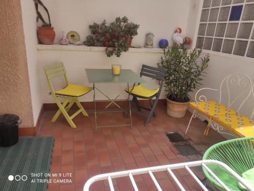 un patio con sillas amarillas, mesa y sillas en Grande chambre avec garage dans quartier historique, en Perpiñán