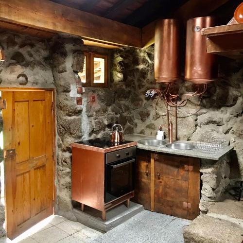 a stone kitchen with a stove and a sink at Quinta dos Carvalhos The Wine House Farm in Center of Lamego - Capital of the Douro in Lamego