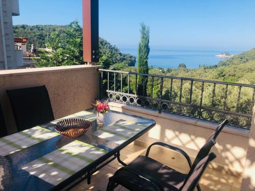 un tavolo e sedie su un balcone con vista sull'oceano di Apartments Villa Lazic a Petrovac na Moru