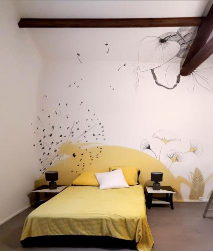 - une chambre avec un lit orné de danses sur le mur dans l'établissement La Forgeolie, à Causses-et-Veyran