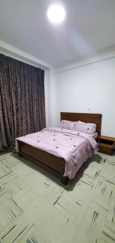 a bedroom with a bed with a pink comforter at Cozy 1-bedroom luxury Apartment in Addis Ababa