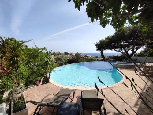 ラゴニッシにある3-house Villa with amazing infinity poolの海の景色を望むプール(椅子付)