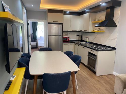 a kitchen with a table and blue chairs at premium park apart otel in Kemer
