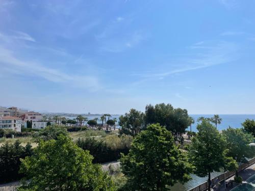 a view of trees and the ocean from a building at VUE SUR MER - Magnifique appartement tout confort - Terrasse et parking privé in Cagnes-sur-Mer