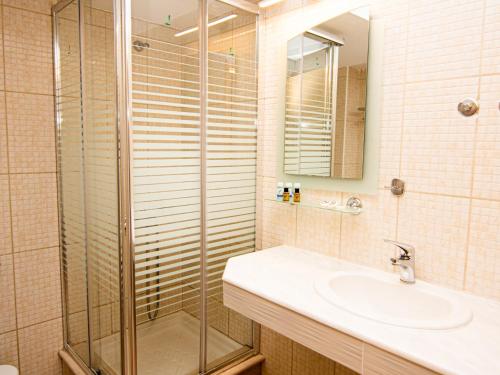 a bathroom with a glass shower and a sink at Afrodite Beach in Nei Poroi