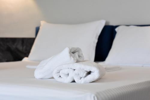 a pile of towels sitting on a bed at Gogo's Boutique Hotel in Dhërmi
