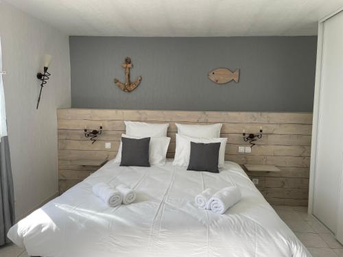 a white bed with two pairs of towels on it at Les trois cèdres in Saint-ouen-dʼAunis