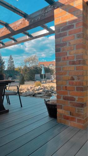 a wooden deck with a brick wall and a bench at Ferienwohnungen Weise im Lausitzer-Seenland in Großräschen