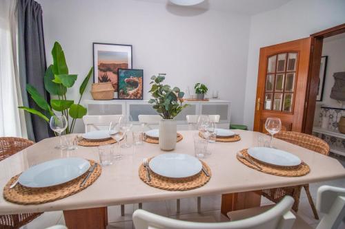 a dining room table with plates and wine glasses at Apartment close to golf, beaches, Quinta Lago, Vale Lobo, Quarteira and Vilamoura in Quinta do Lago