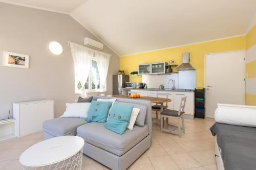 salon z kanapą i kuchnią w obiekcie Apartment PORTAPISANA just 50m from the beach w Krku