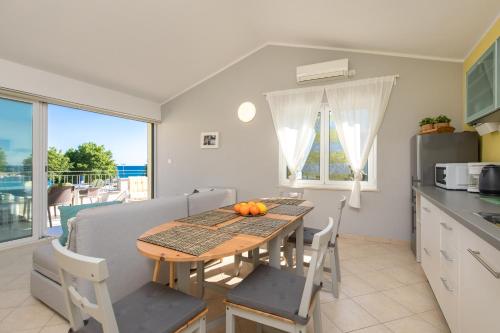 クルクにあるApartment PORTAPISANA just 50m from the beachのテーブルと椅子のあるキッチンとダイニングルーム