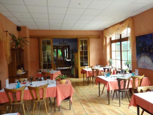 ein Restaurant mit Tischen, Stühlen und rosafarbenen Tischdecken in der Unterkunft Hotel-Restaurant du Windstein in Windstein