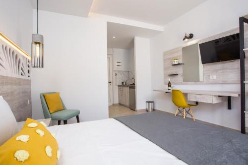 a bedroom with a bed and two chairs and a desk at Casa Stavris in Faliraki