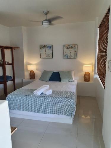a bedroom with a bed with two lamps on it at Beachside Apartment 1 with plunge pool in Port Douglas
