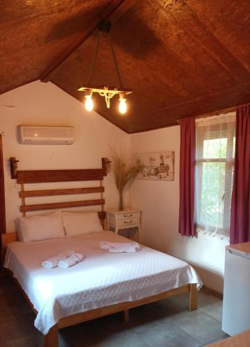 a bedroom with a bed with two towels on it at Canario Bungalows in Cıralı