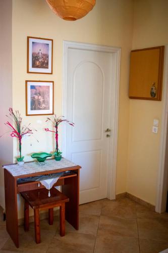 a room with a wooden table and a white door at FILIS APARTMENT in Áyios Andréas Messinias