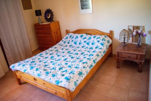 1 dormitorio con 1 cama con edredón azul y blanco en FILIS APARTMENT, en Agios Andreas - Mesenia