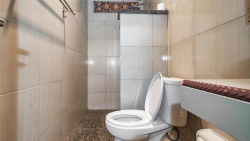 a bathroom with a white toilet and a bath tub at The Village Guest House in Ubud