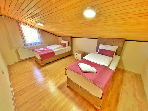a room with two beds and a wooden ceiling at Şahin Apart in Uzungol