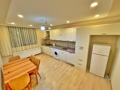 a kitchen with a table and a refrigerator in it at Şahin Apart in Uzungol