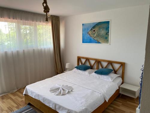 a bedroom with a bed with a fish picture on the wall at Pensiunea Știuca Șchioapă in Băltenii de Sus