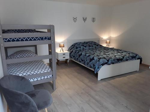 a bedroom with two bunk beds and a chair at Gite de la Diligence in Le Fied