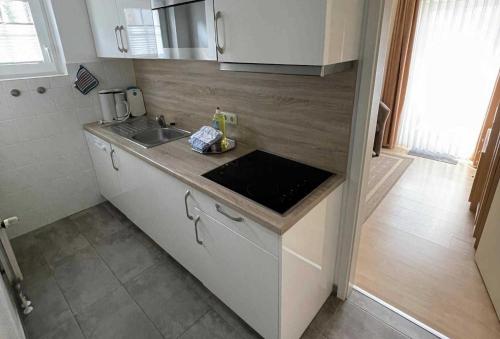 eine Küche mit einer Spüle und einer Arbeitsplatte in der Unterkunft Haus Kiek Ut Apartment 24 in Timmendorfer Strand