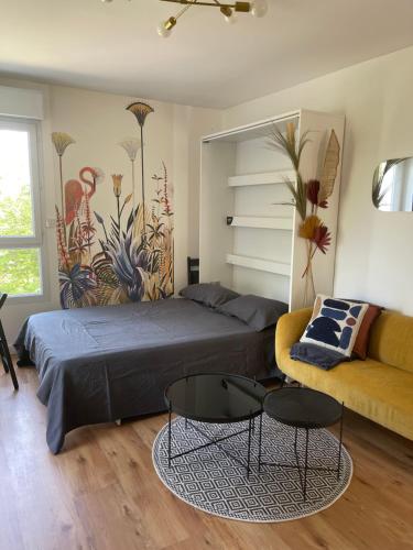 a bedroom with a bed and a couch at Studio quartier prisé de la Genette in La Rochelle