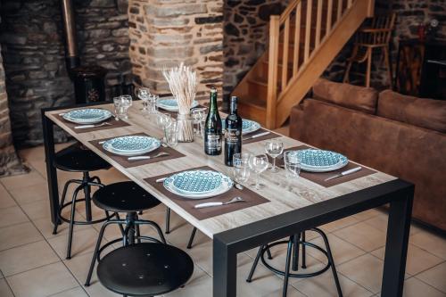 a table with plates and wine bottles and glasses at Rare, belle maison de 90 m2 au pied du château in Fougères