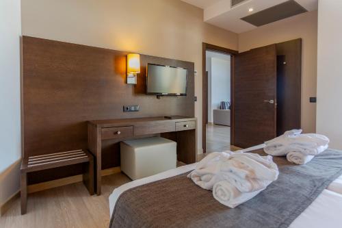 a hotel room with a bed and a desk with towels at Marins Beach Club - Adults Only Hotel in Cala Millor