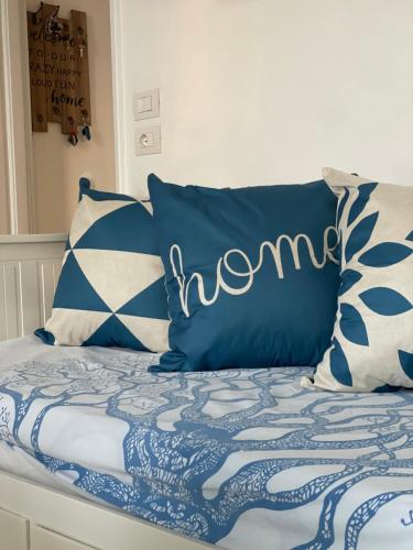 a bed with blue and white sheets and pillows at Casa Libera in Savelletri di Fasano