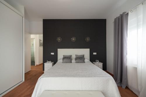 a bedroom with a large bed with a black wall at DREAM HOUSE in Burriana
