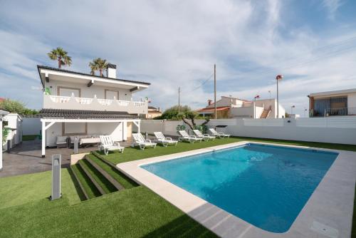 a villa with a swimming pool in front of a house at DREAM HOUSE in Burriana