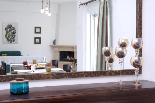 a living room with a mirror and a table with wine glasses at Haris Villas in Keratokampos